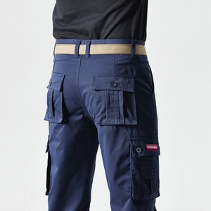 Detail of dark blue cargo pants with rear flap pockets and fashion label accent