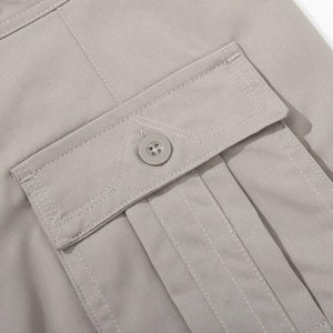 Detailed close-up of light grey cargo pants showing pocket flap and durable cotton twill fabric