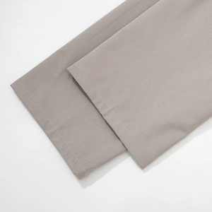 Close-up detail of smooth flat-weave fabric and neat stitching on men cargo pants hem
