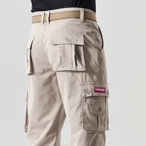 Detail view of khaki cargo pants with side flap pockets and a dark brown nylon belt