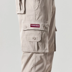 Detailed view of cargo pant side flap pocket with red fashion wear woven label