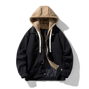 Detail of black corduroy men's jacket with khaki hood and silver metal button closure