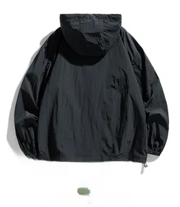 Detail view of the back of a lightweight black hooded windbreaker with elastic cuffs