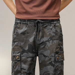 Dettaglio di pantaloncini cargo mimetici con vita elastica, coulisse e gancio a D in metallo