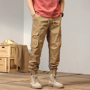 Close-up of khaki cargo pants featuring large side flap pockets and elastic cuffs