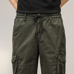 Dettaglio dei pantaloncini cargo verde militare con coulisse elastica e tasche laterali