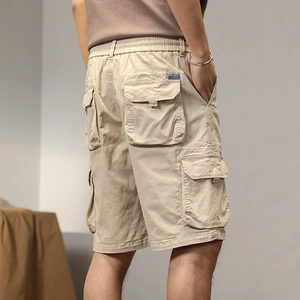 Dettaglio dei pantaloncini cargo kaki con tasche laterali e vita elastica indossati dal modello