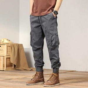 Detail of dark grey cargo pants featuring large side pockets and zippered ribbed cuffs