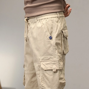 Dettaglio dei pantaloncini cargo kaki con grande tasca a patta e trama del cotone
