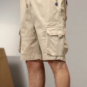 Dettaglio dei pantaloncini cargo kaki con grande tasca a patta e trama in twill
