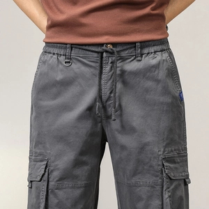 Detail of men's cargo pants showing elastic drawstring waist and metal D-ring attachment