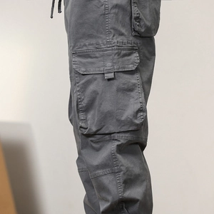 Detailed close-up of dark grey cargo pants featuring a 3D side pocket and cotton twill texture
