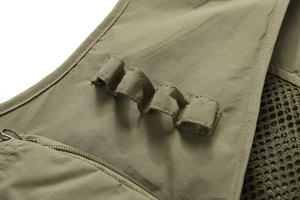 Gros plan du gilet tactique vert olive montrant la poche zippée et la doublure en filet