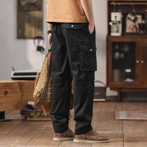 Détail du pantalon cargo noir en coton avec de grandes poches et coutures robustes