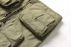 Gros plan du gilet multi-poches vert olive avec détails zippés et texture résistante