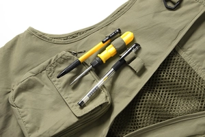 Détail du gilet cargo vert militaire avec poches zippées, anneau en D et doublure filet