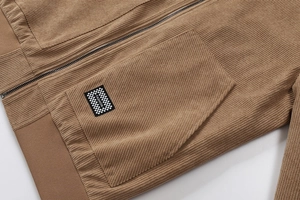 Detail van bruin corduroy jack met grove textuur rits en modieus zaklabel voor heren
