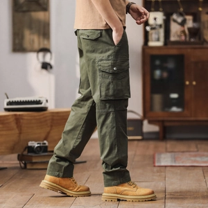 Vue détaillée du pantalon cargo vert armée avec grandes poches latérales et boutons en métal