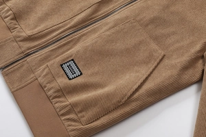 Detail van een bruin corduroy jack met geribbelde textuur en modieuze patch-stijl