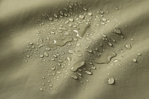 Détail du tissu résistant à l'eau avec gouttelettes hydrophobes sur un gilet d'extérieur