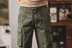 Détail du pantalon cargo vert olive avec taille élastique à cordon et grandes poches à rabat