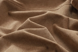 Detailopname van hoogwaardige bruine corduroy stof met dikke verticale streeptextuur
