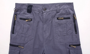 Detail of dark blue cargo shorts featuring multi-pockets with vintage metal zippers and D-ring