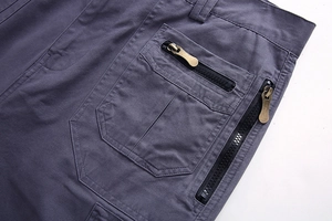 Detailed close-up of dark grey cargo shorts featuring durable metal zippers and utility pockets