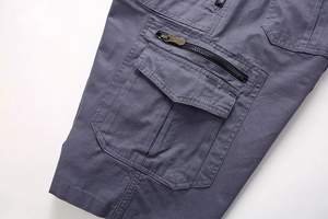 Detailed macro view of side cargo pocket with bronze metal zipper on cotton shorts