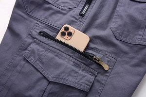 Detail of dark gray cargo shorts pocket with durable metal zipper and cotton texture