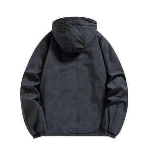 Detalle de la tela negra de la chaqueta con patrones geométricos y puños elásticos