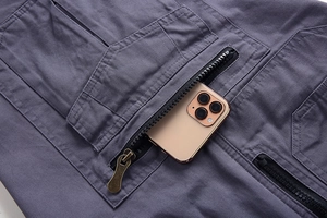 Detail of cargo shorts large pocket with zipper holding a smartphone for scale