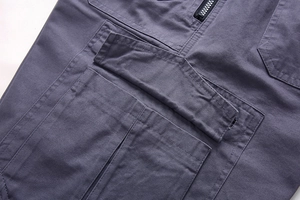 Detailed macro view of the cargo pocket and double stitching on grey cotton pants