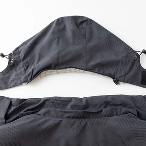 Detalle de chaqueta gris de invierno con diseño geométrico cortavientos y forro de felpa