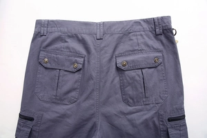 Detail view of cotton cargo shorts showing rear pockets with metal snaps and zip closures