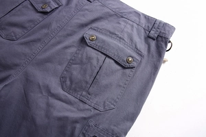 Detailed close-up of blue cargo shorts with twill texture and fashion metal button