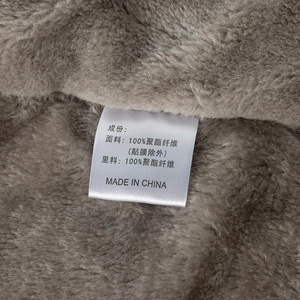 Detalle del forro polar de 100% poliéster y la etiqueta de material de la chaqueta de invierno
