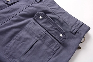Detail view of cotton cargo shorts showing large side pockets with metal snap buttons