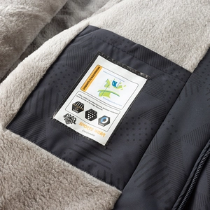 Detalle del forro polar gris suave y bolsillo interior impermeable con etiquetas técnicas