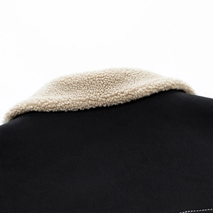 Detailed macro view of soft white sherpa fleece collar on a heavy black winter jacket