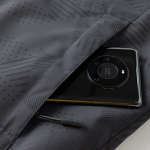 Detalle de chaqueta de invierno con estampado geométrico y bolsillo con cremallera