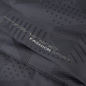 Vista detallada del tejido gris oscuro de la chaqueta con estampado 'Training'