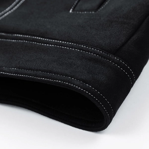 Detailed close-up of heavy matte suede fabric with white contrast stitching on a winter jacket