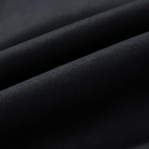 Macro detail of high-quality heavy black fabric with fine matte texture and soft folds
