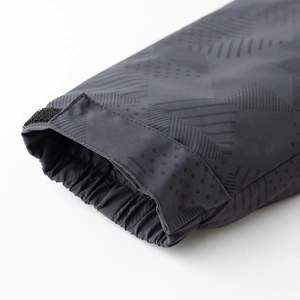 Detalle de puños elásticos cortavientos y correas de velcro en la chaqueta gris oscuro