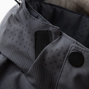 Detalle de chaqueta de invierno en tela impermeable gris oscuro con velcro y botón de presión