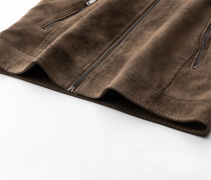 Details vom dunkelbraunen Wildleder-Jackensaum mit Metallreißverschlüssen und Nähten