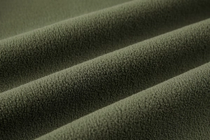 Macro detail of military green fleece fabric showing thick warm texture and soft fibers