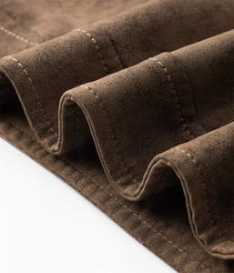 Makroaufnahme der dunkelbraunen Wildlederjacke mit Doppelnaht und sauberem Saum-Detail