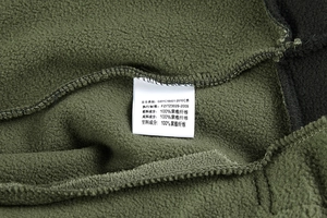Close-up of army green fleece jacket lining showing soft texture and washing label